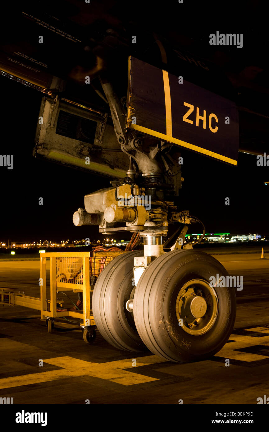 The giant nose wheel of a Boeing 747-400 airliner is parked on the apron area during its overnight turnaround, Heathrow Airport Stock Photo