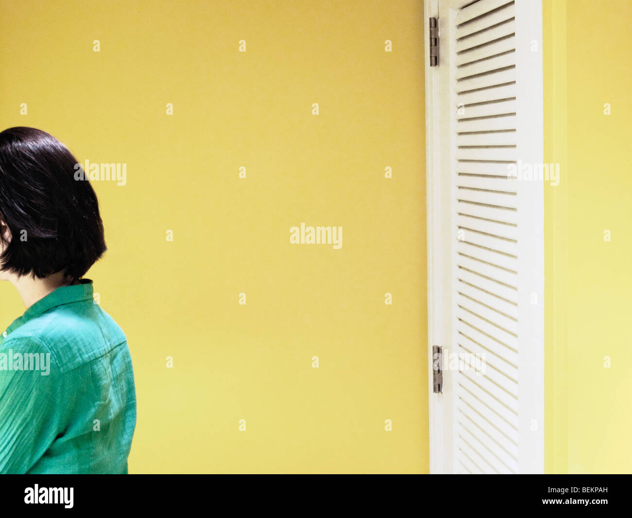 Young Woman Standing In Yellow Room Stock Photo