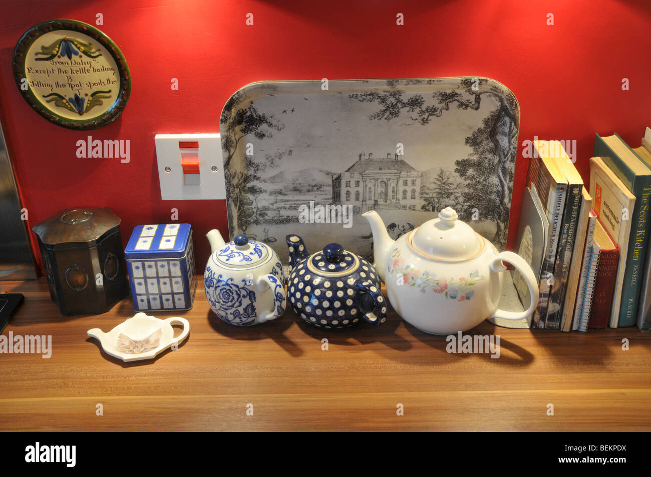 A section of a kitchen work top showing teapots, trays, cookery books  etc..... Stock Photo