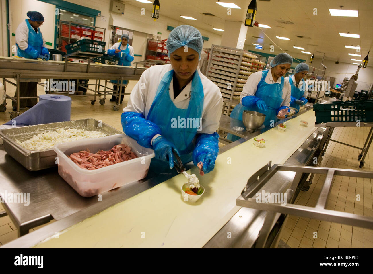 A production line of lady employees from Gate Gourmet prepare airline salad trays at Heathrow Airport. Stock Photo