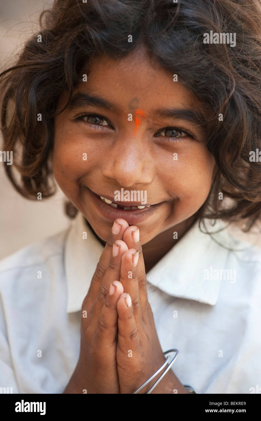 Young Indian street girl greeting with folded hands and a happy smiling face. Selective focus. Stock Photo