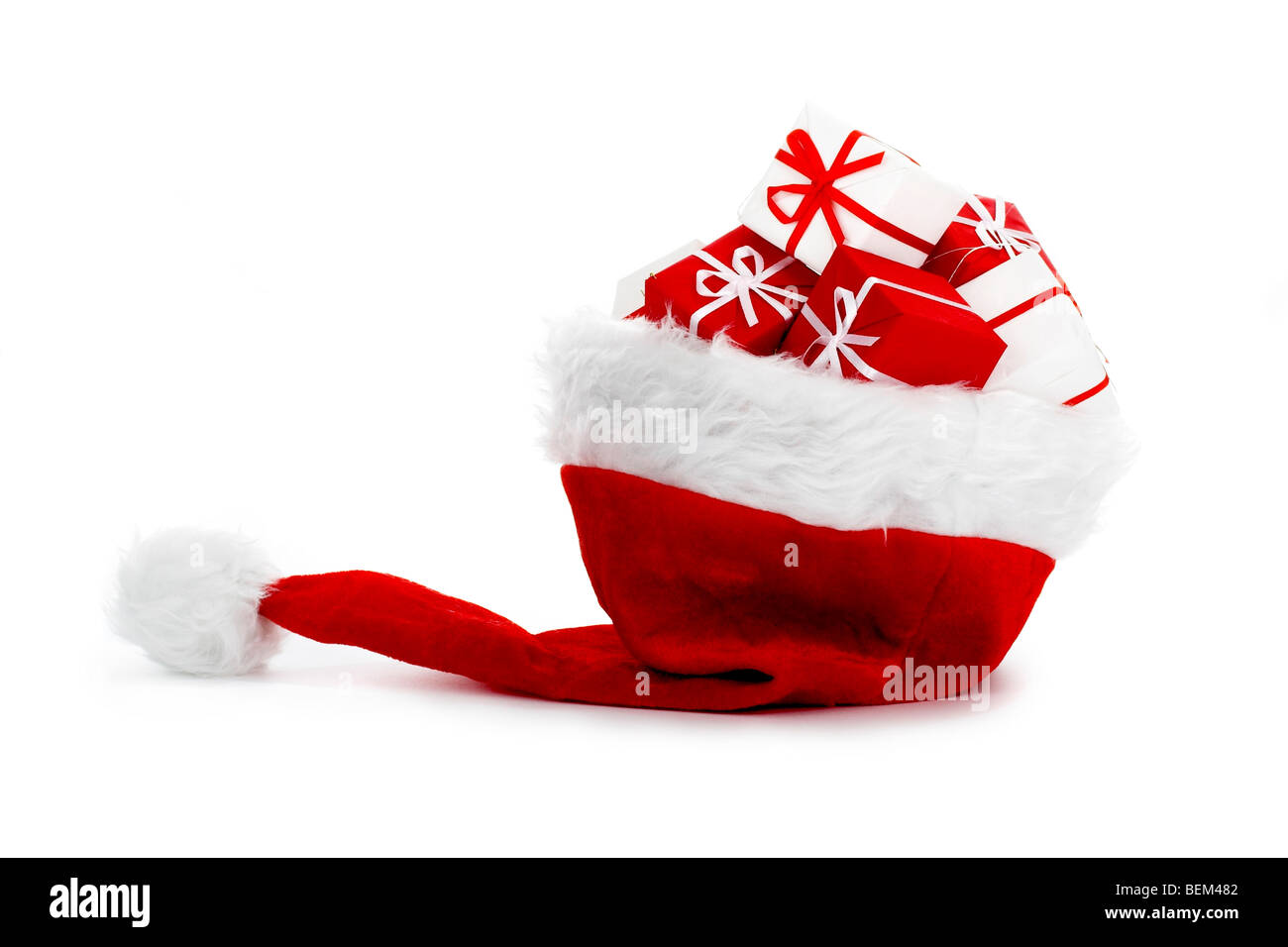 A red Santa hat with gifts isolated on white background Stock Photo - Alamy