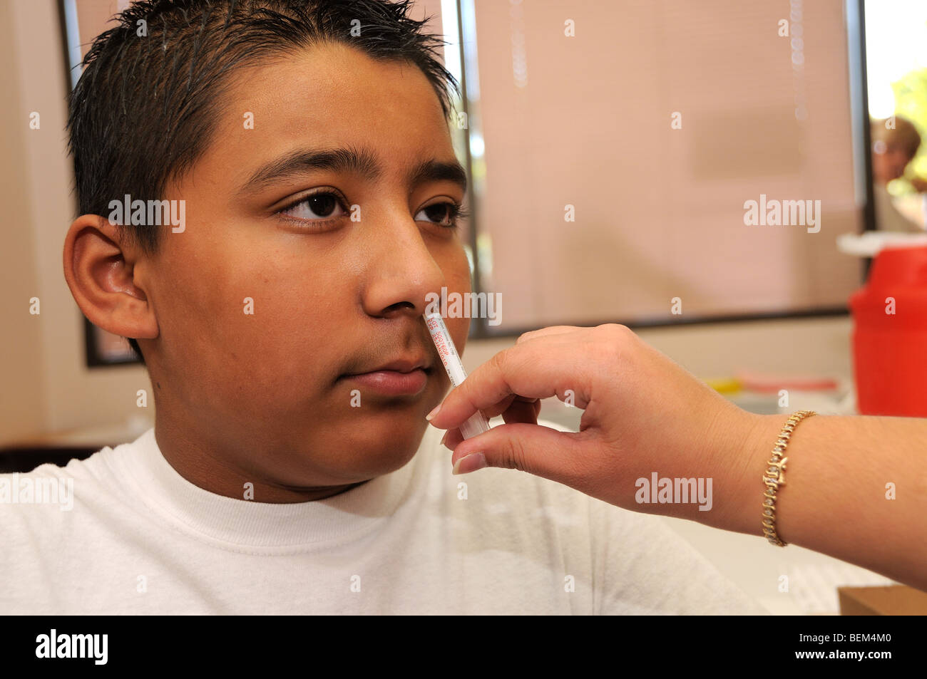 A 12-year-old boy is vaccinated for the 2009 H1N1 influenza, also known as the Swine Flu, with an intranasal vaccine. Stock Photo