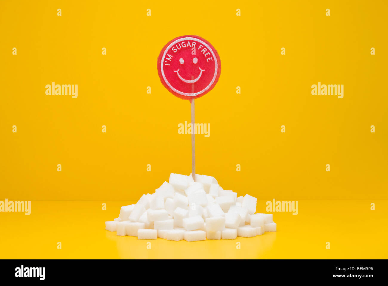 Food concept, sugar-free lollipop sticking out of pile of sugar cubes Stock Photo