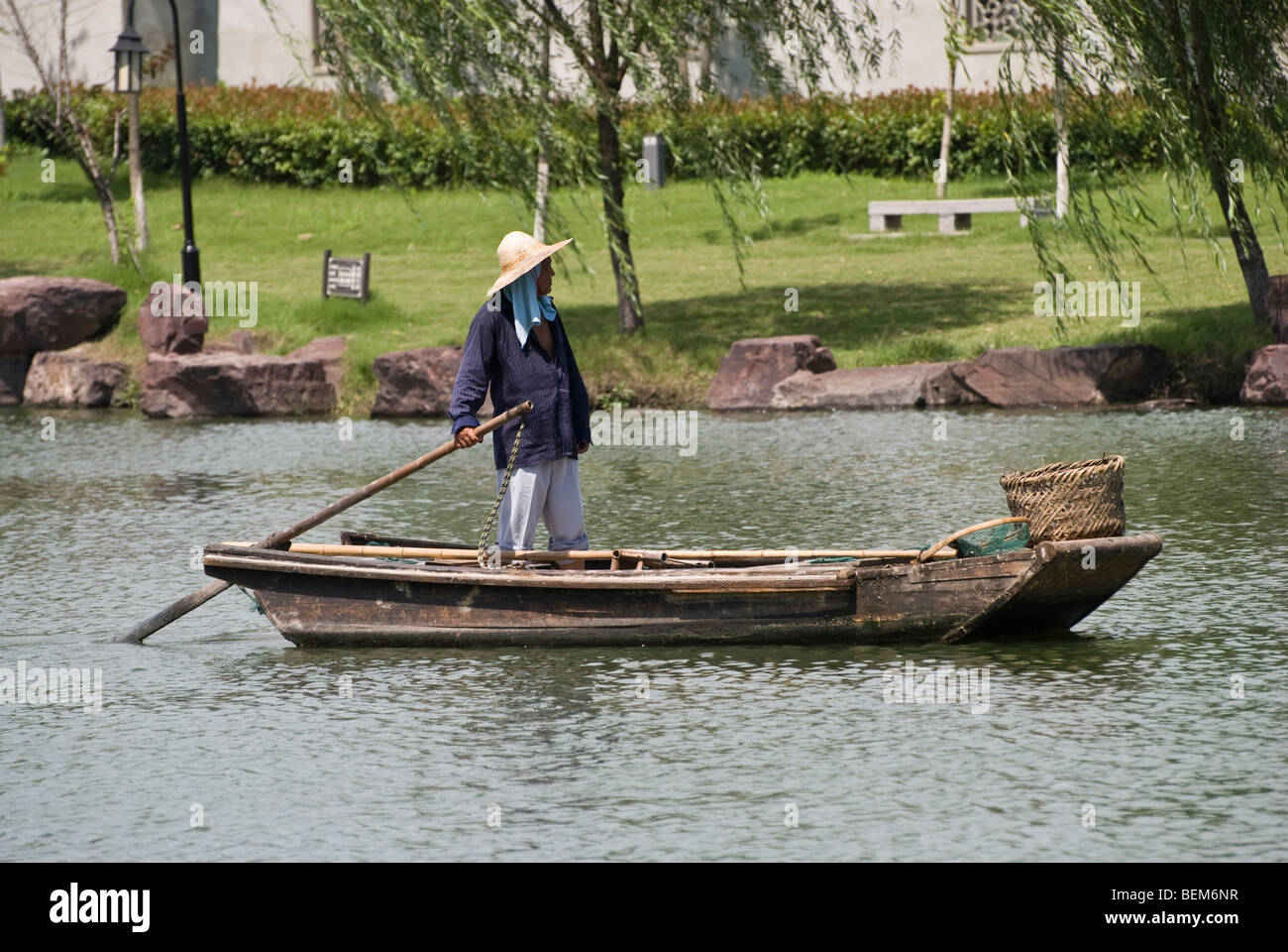 Man in a ancient wooden boat in a river of Xitang Xitang is an ancient scenic town in Jiashan County, Zhejiang Province, China. Stock Photo