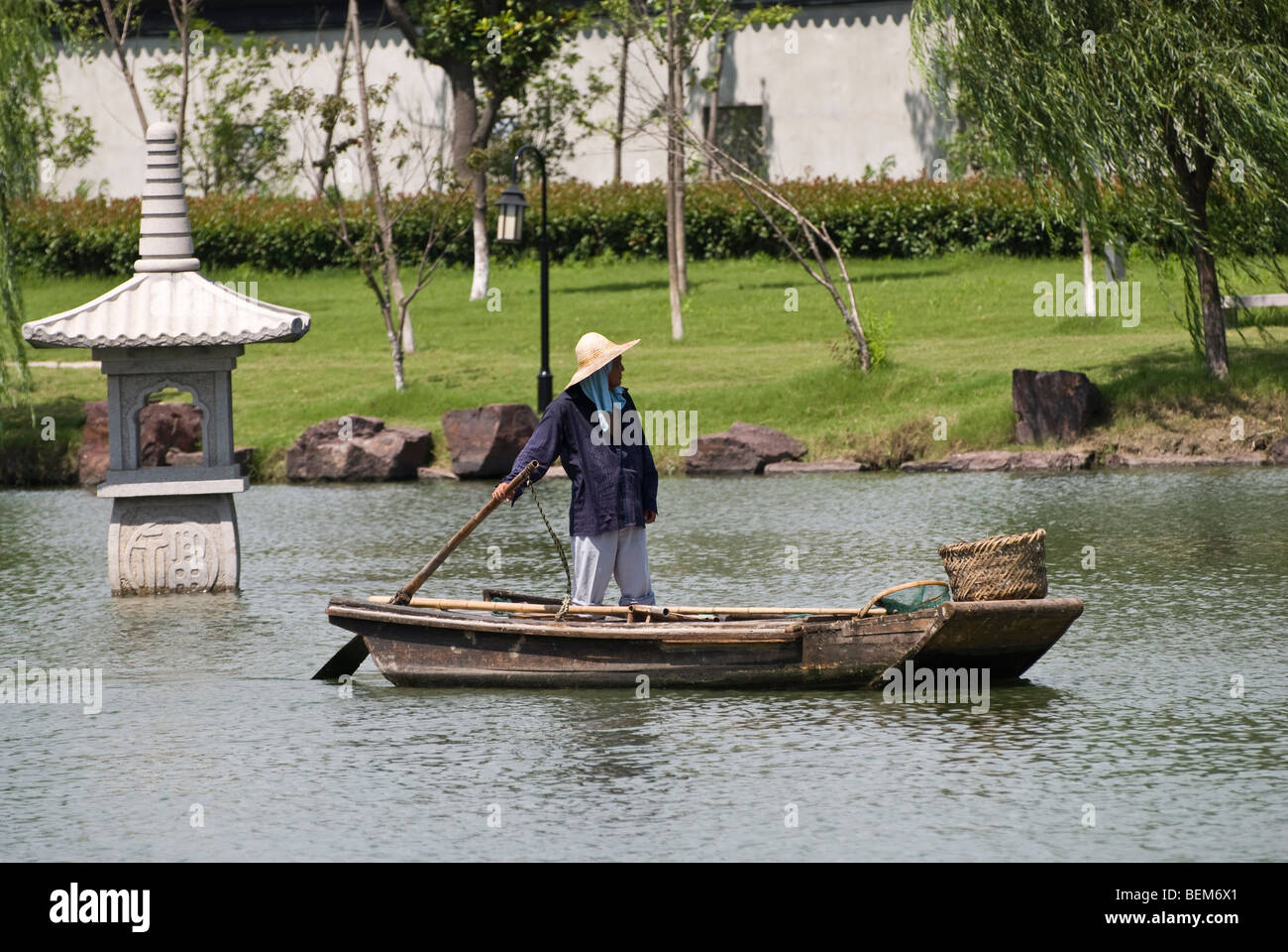 Man in a ancient wooden boat in a river of Xitang Xitang is an ancient scenic town in Jiashan County, Zhejiang Province, China. Stock Photo