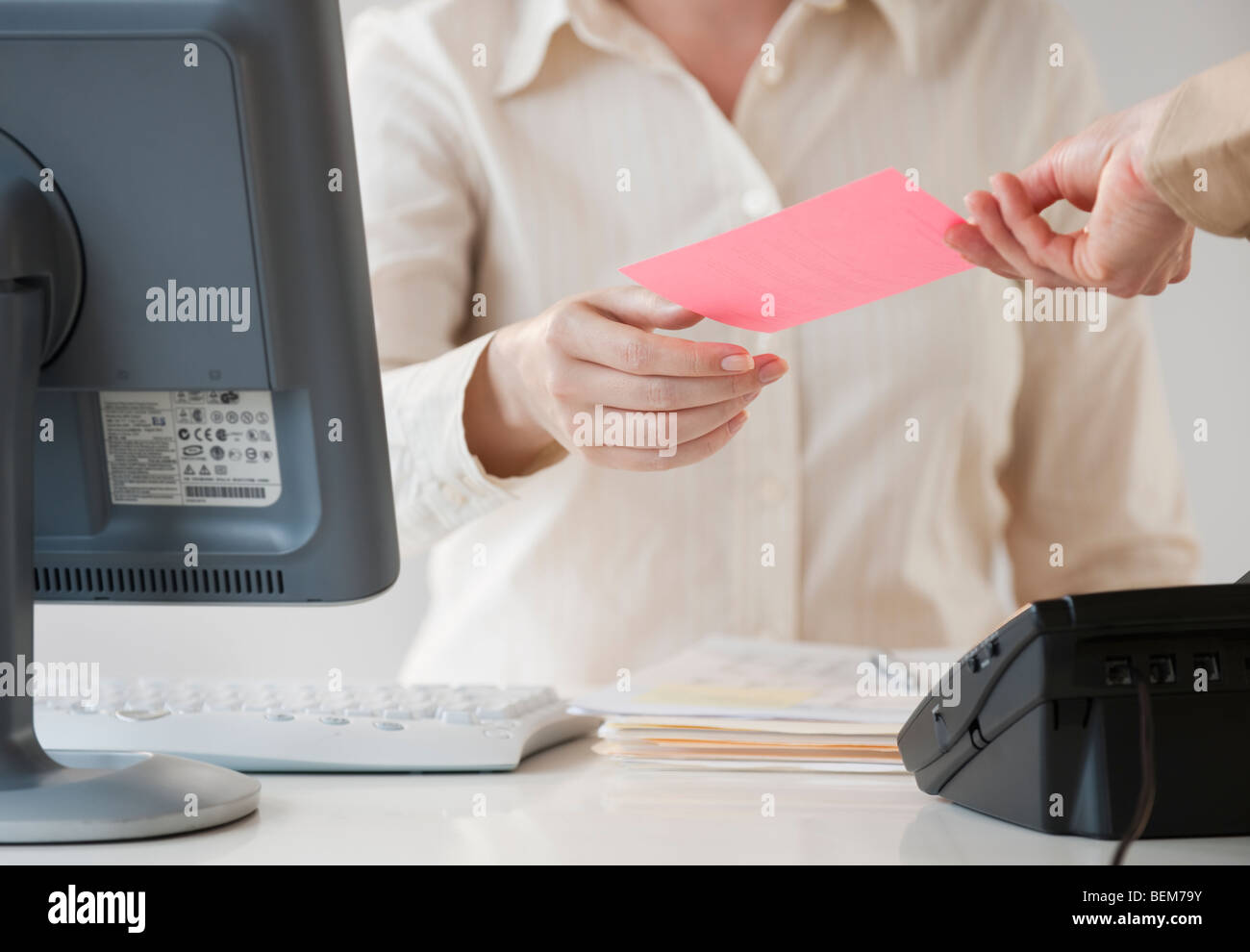 Hand passing note to office worker Stock Photo