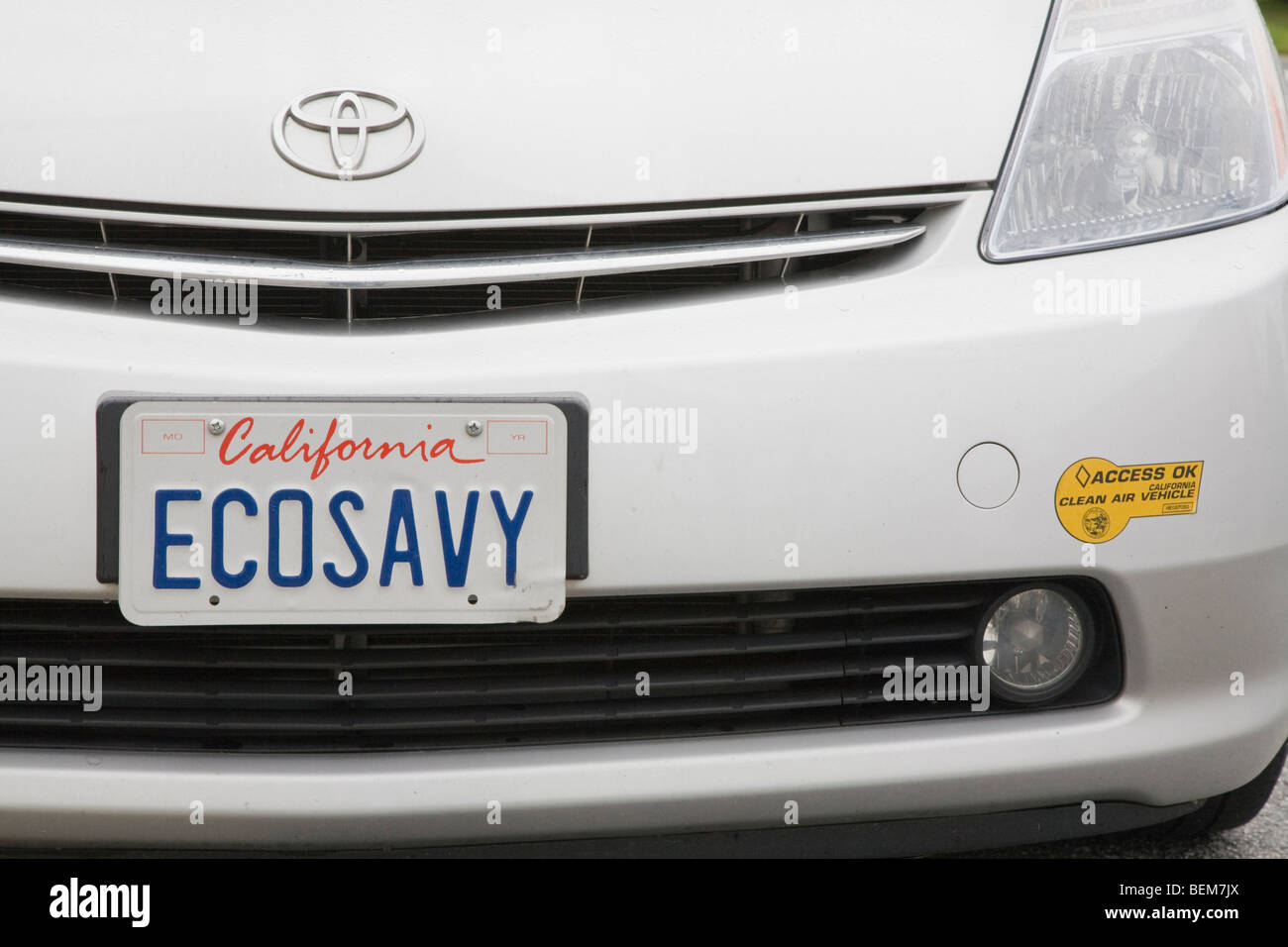 A close up of a Toyota Prius with a 'ECOSAVY' (Eco Savvy) license plate and a clean air vehicle sticker. Stock Photo