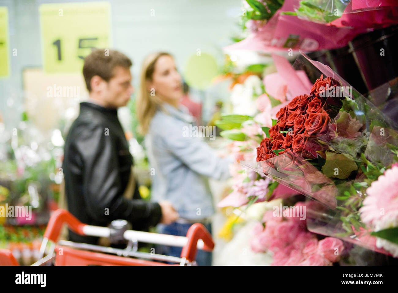 Flower bouquets at flower shop, couples browsing in background Stock Photo