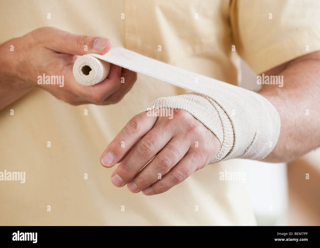 Man wrapping hand in tensor bandage Stock Photo