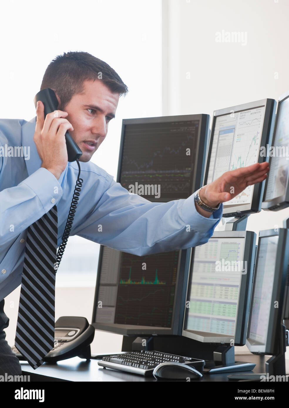 Trader studying computer screens Stock Photo
