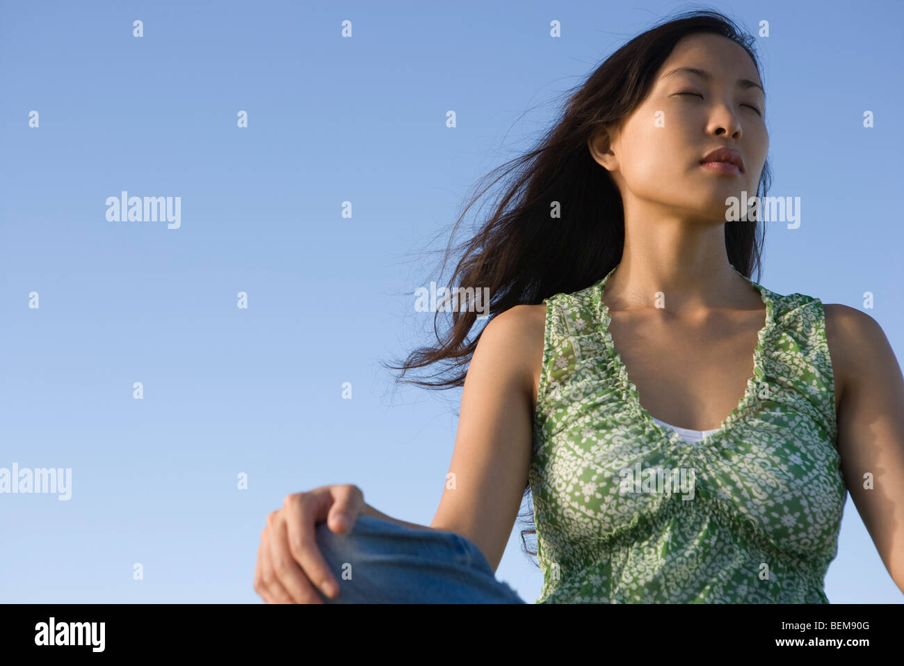 Woman sitting outdoors with eyes closed Stock Photo - Alamy