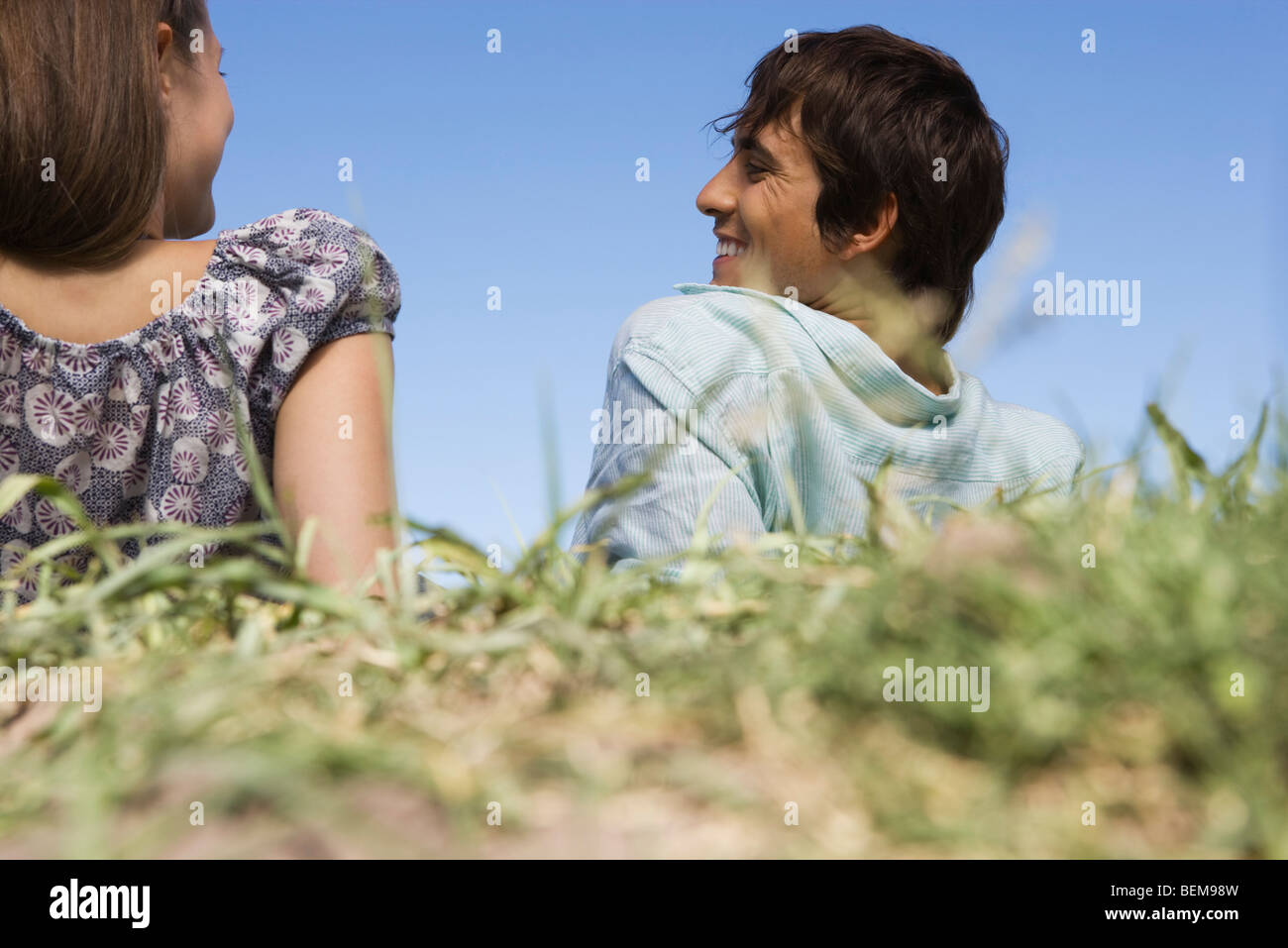 Young couple relaxing in grass, rear view Stock Photo - Alamy