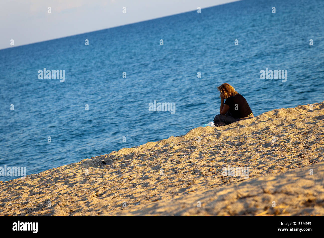 San Teodoro beach at the sunset with people. Woman at the beach at sunset. Stock Photo