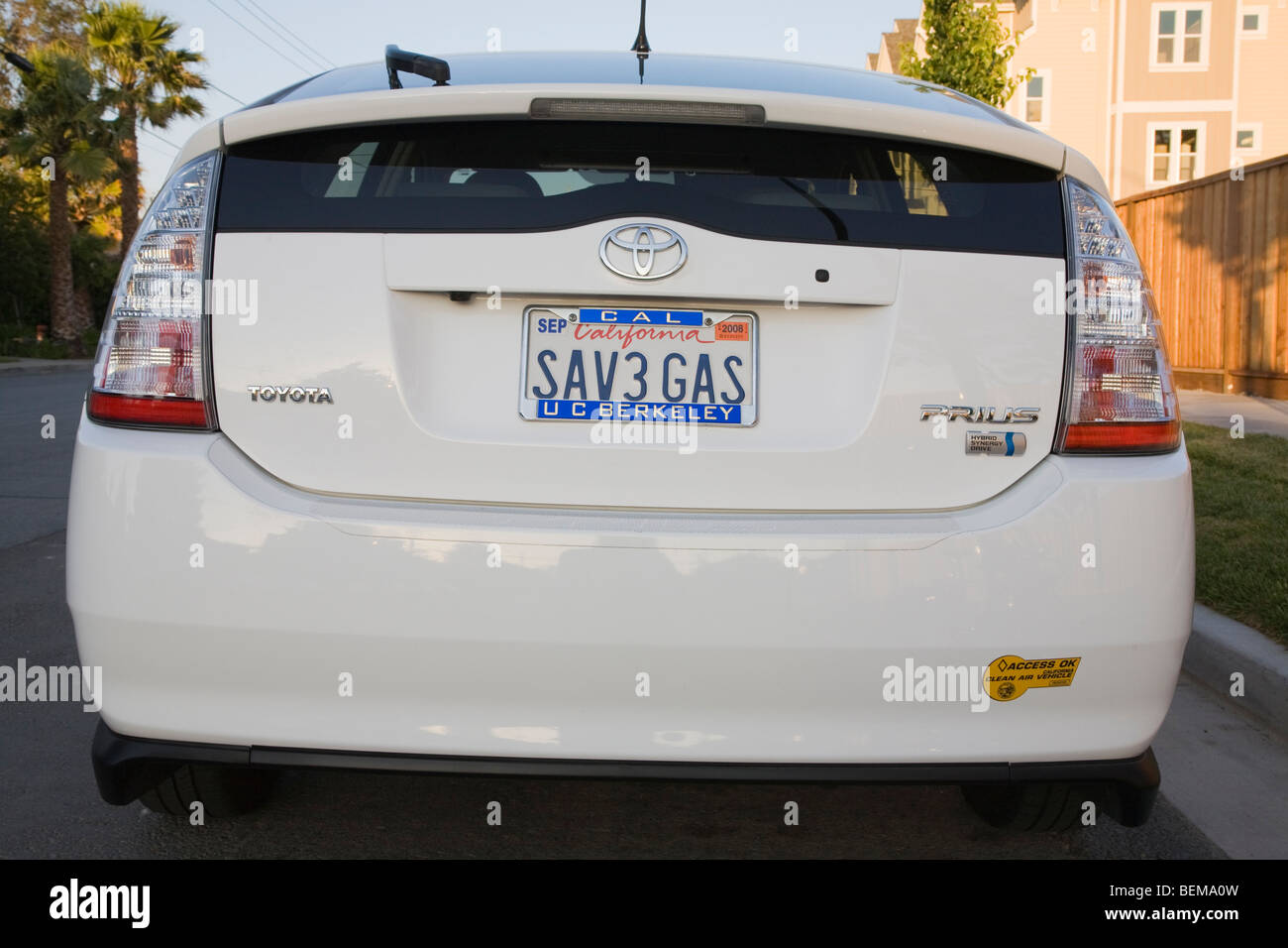 Rear view of white Toyota Prius with a 'SAV3 GAS' (Save Gas) license plate and a clean air vehicle sticker. Stock Photo