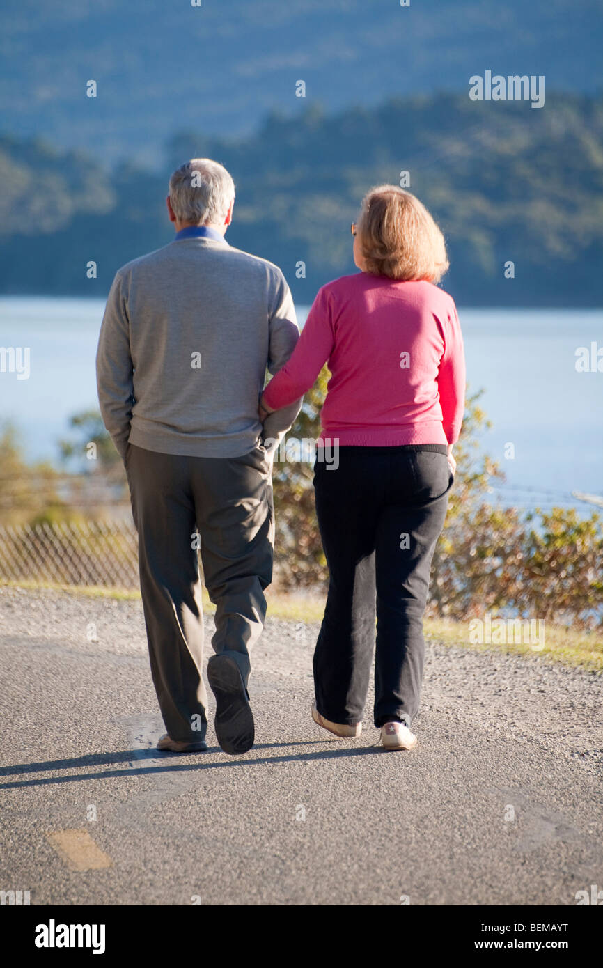 A rear view of a senior couple walking at Crystal Springs Reservoir on Sawyer Camp Trail. San Mateo, California, US Stock Photo