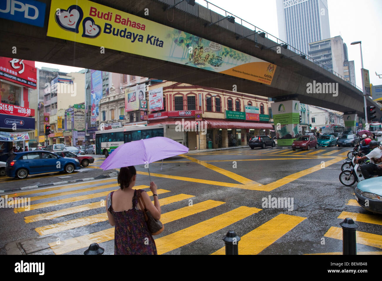 A road junction with an elevated RapidKL railway in a rainy downtown Kuala Lumpur. Kuala Lumpur, Selangor, Malaysia Stock Photo