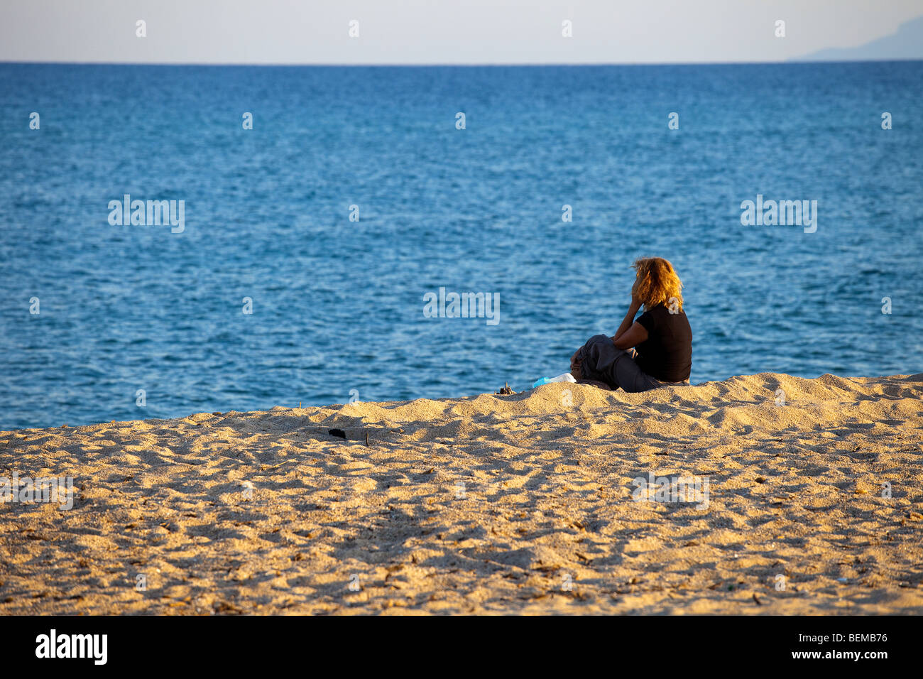 San Teodoro beach at the sunset with people. Sardinia, Italy. Woman on the beach Stock Photo