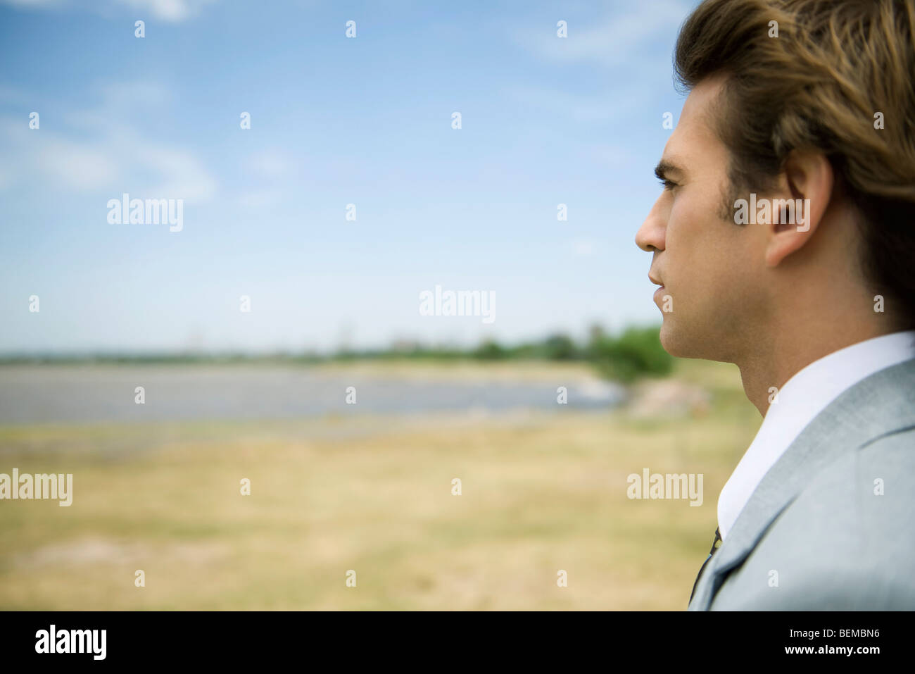 Man at lake shore contemplatively looking at view Stock Photo - Alamy
