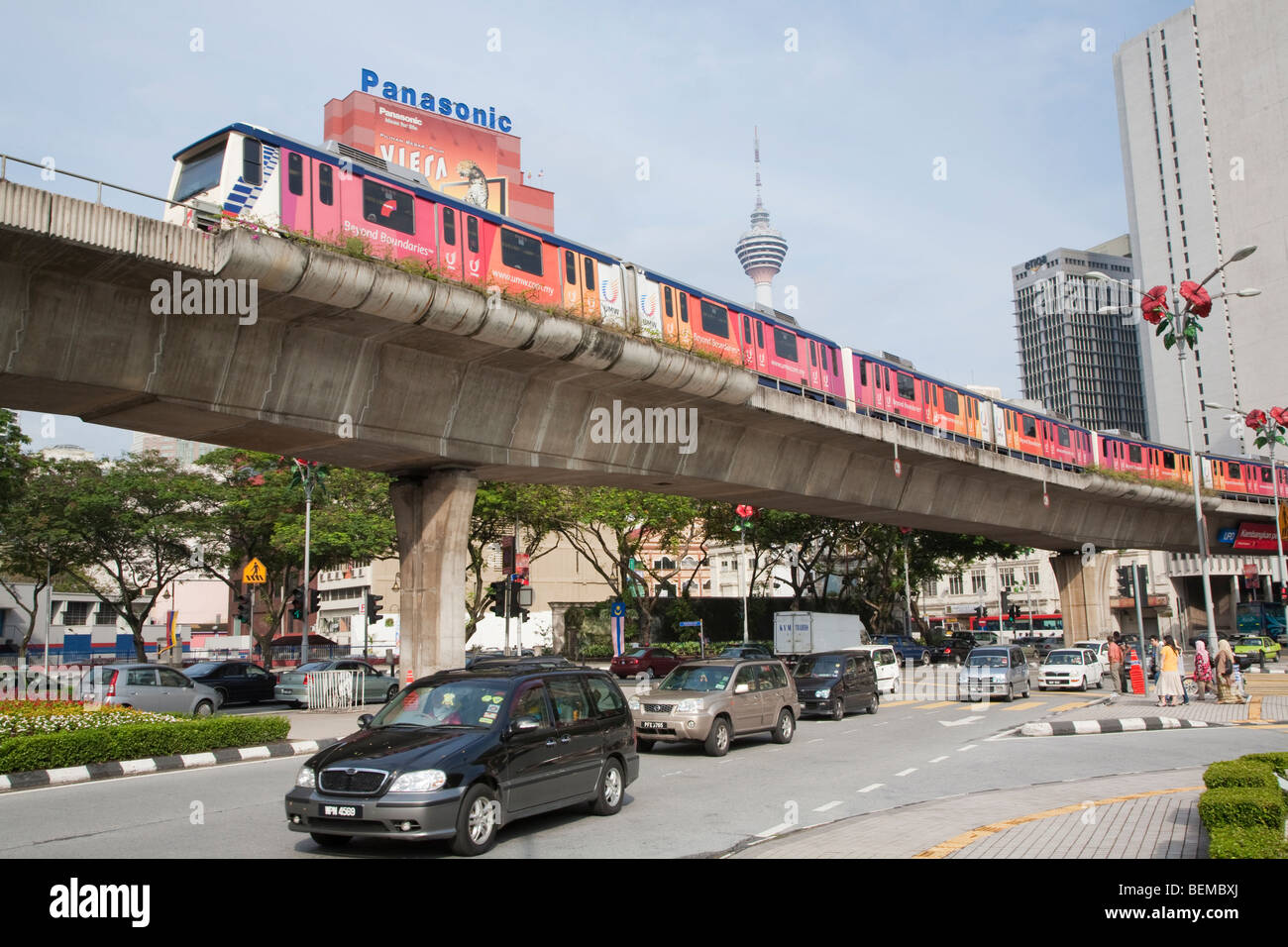 A road junction with a RapidKL train traveling on an elevated railway in downtown Kuala Lumpur, Malaysia. Stock Photo