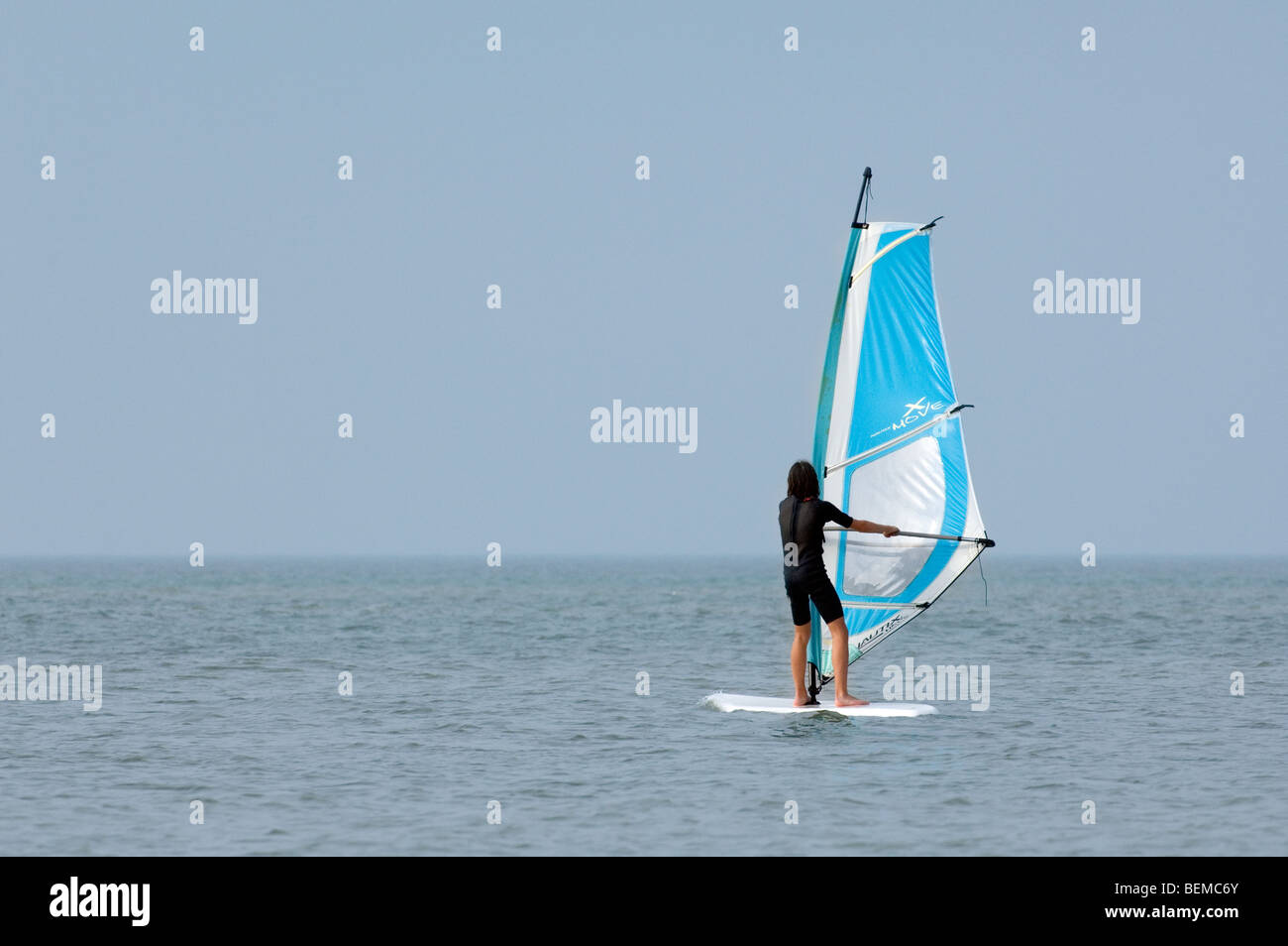 Young girl windsurfing along the North Sea coast Stock Photo