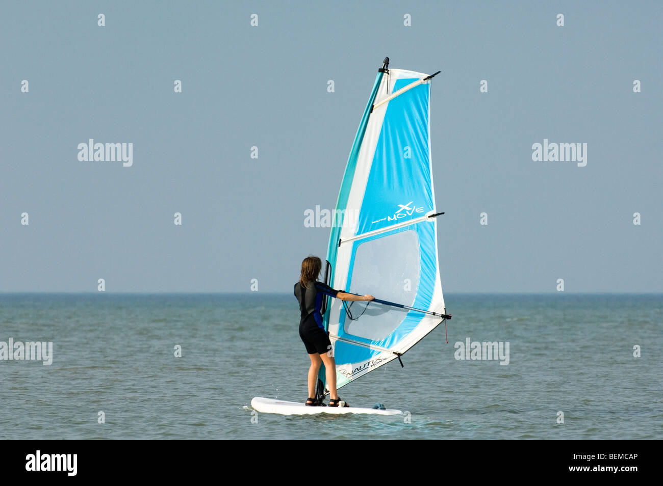 Young girl windsurfing along the North Sea coast Stock Photo