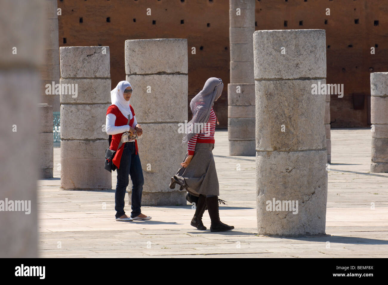 Visitors walk among the columns of the prayer hall of The Unfinished Hassan Mosque, Rabat, Morocco, Africa. Stock Photo