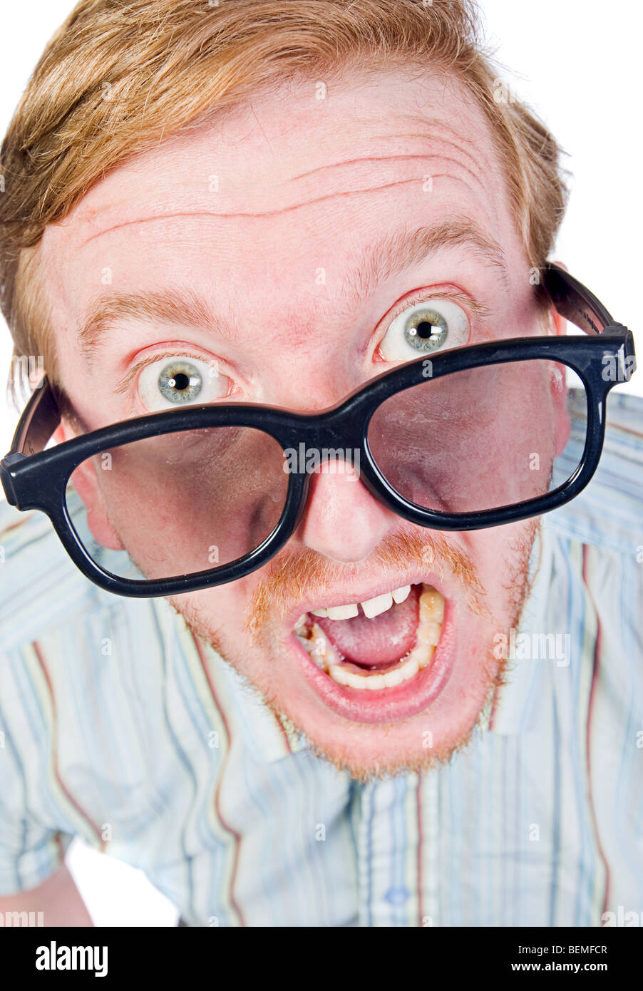 Shot of an Angry Red Headed Geek with Thick Rimmed Glasses Stock Photo