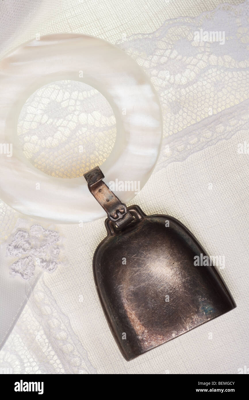 vintage baby rattle with mother of pearl ring isolated on a white linen Stock Photo