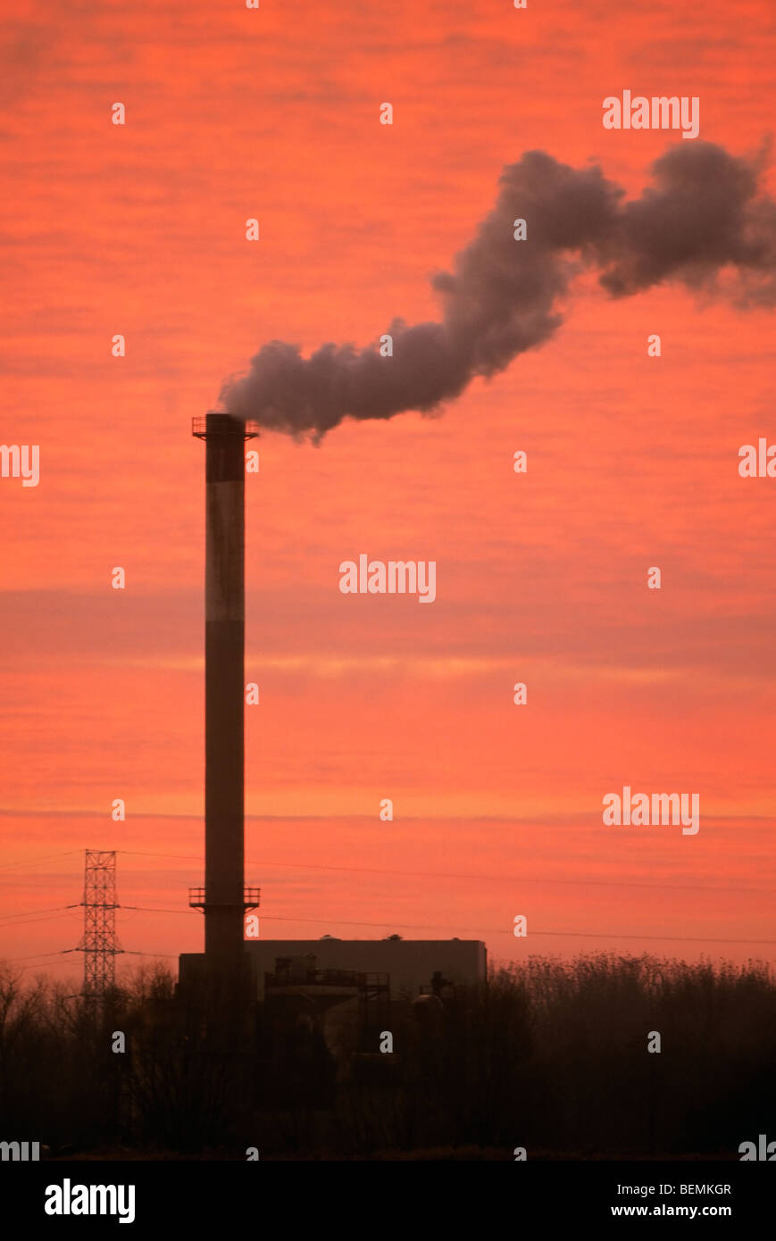 Chimney at industrial estate with smoke at sunset Stock Photo - Alamy