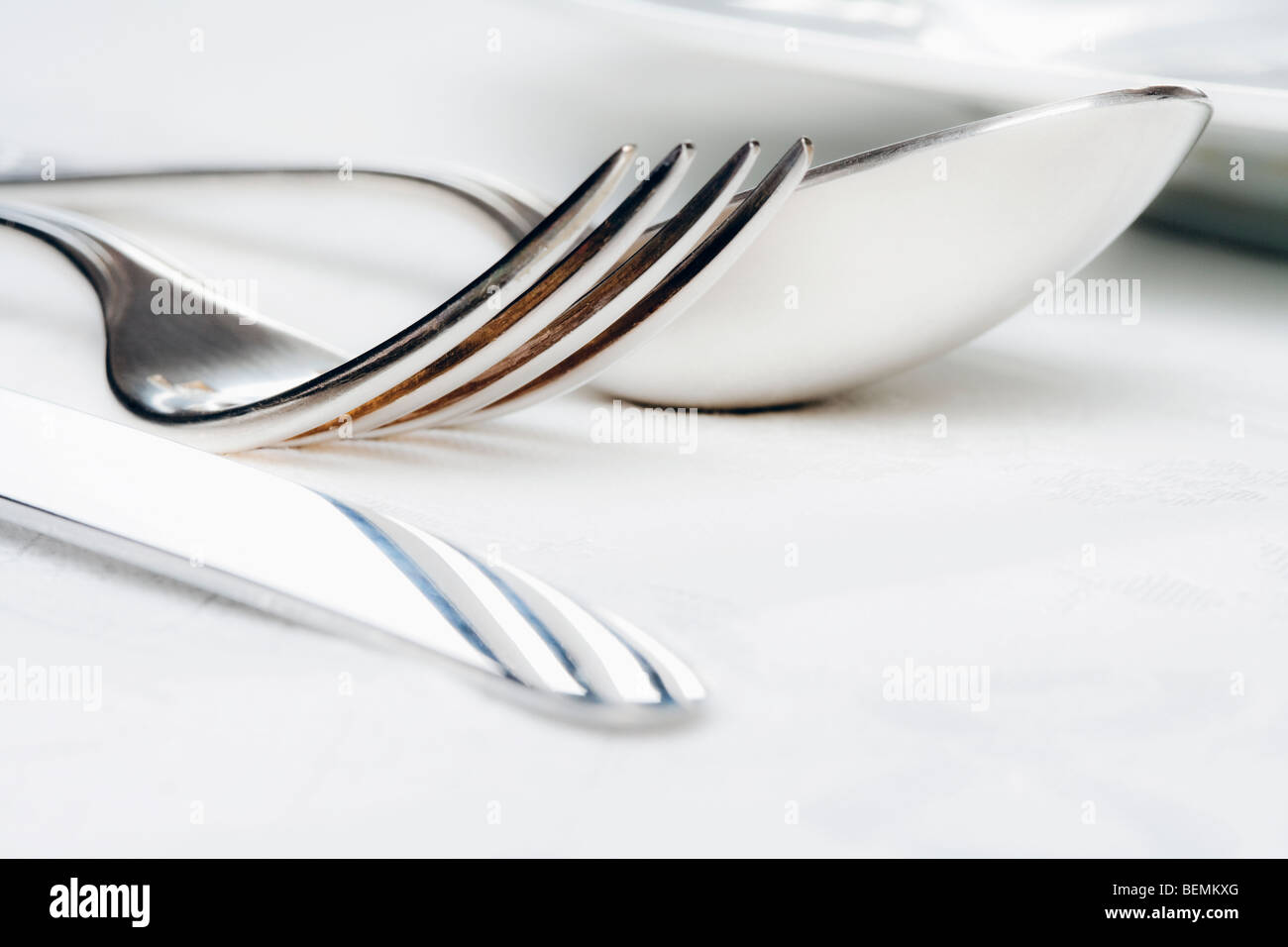 elegant table setting with silverware on white cloth Stock Photo - Alamy