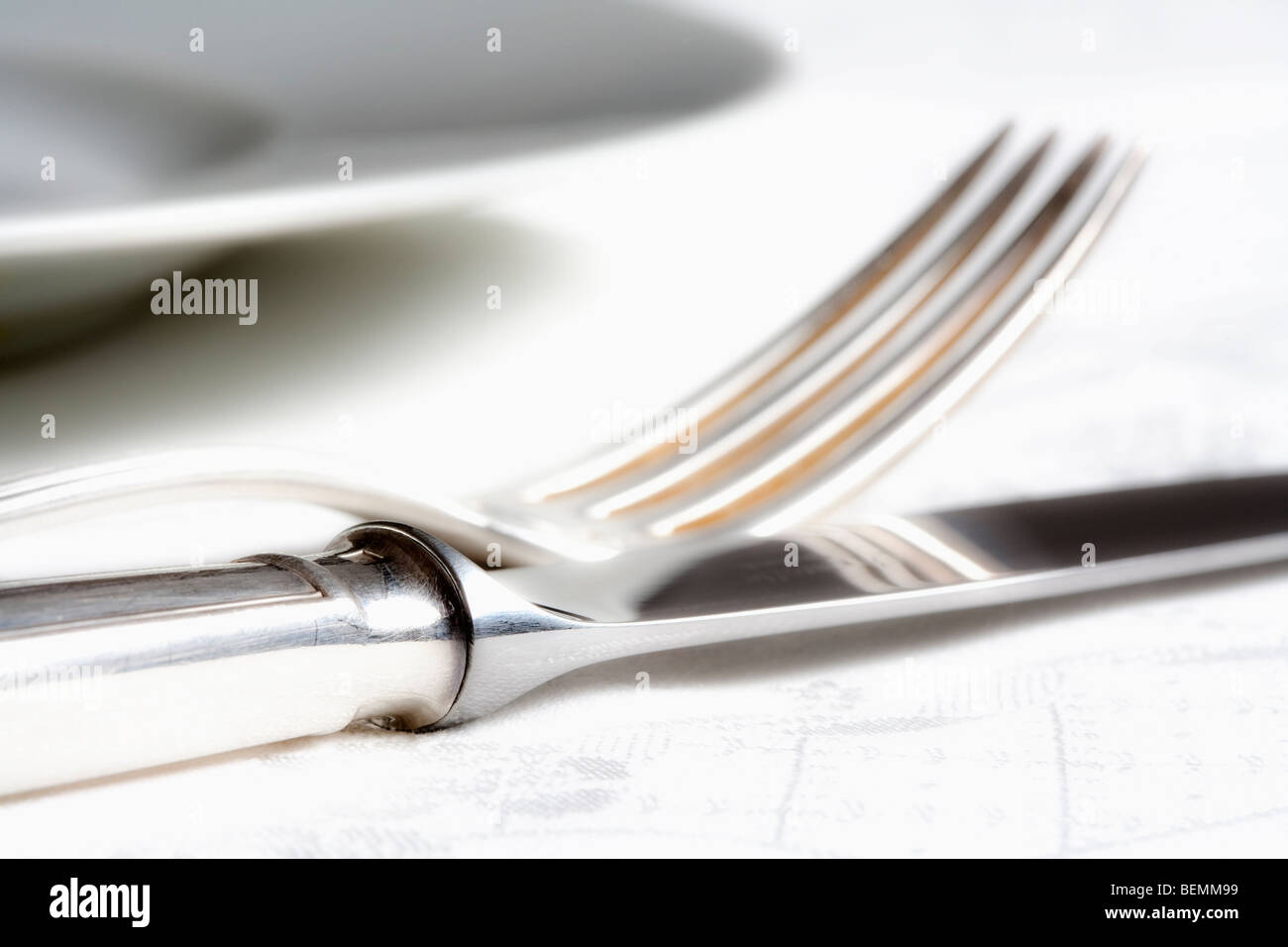 elegant table setting with silverware on white cloth Stock Photo - Alamy