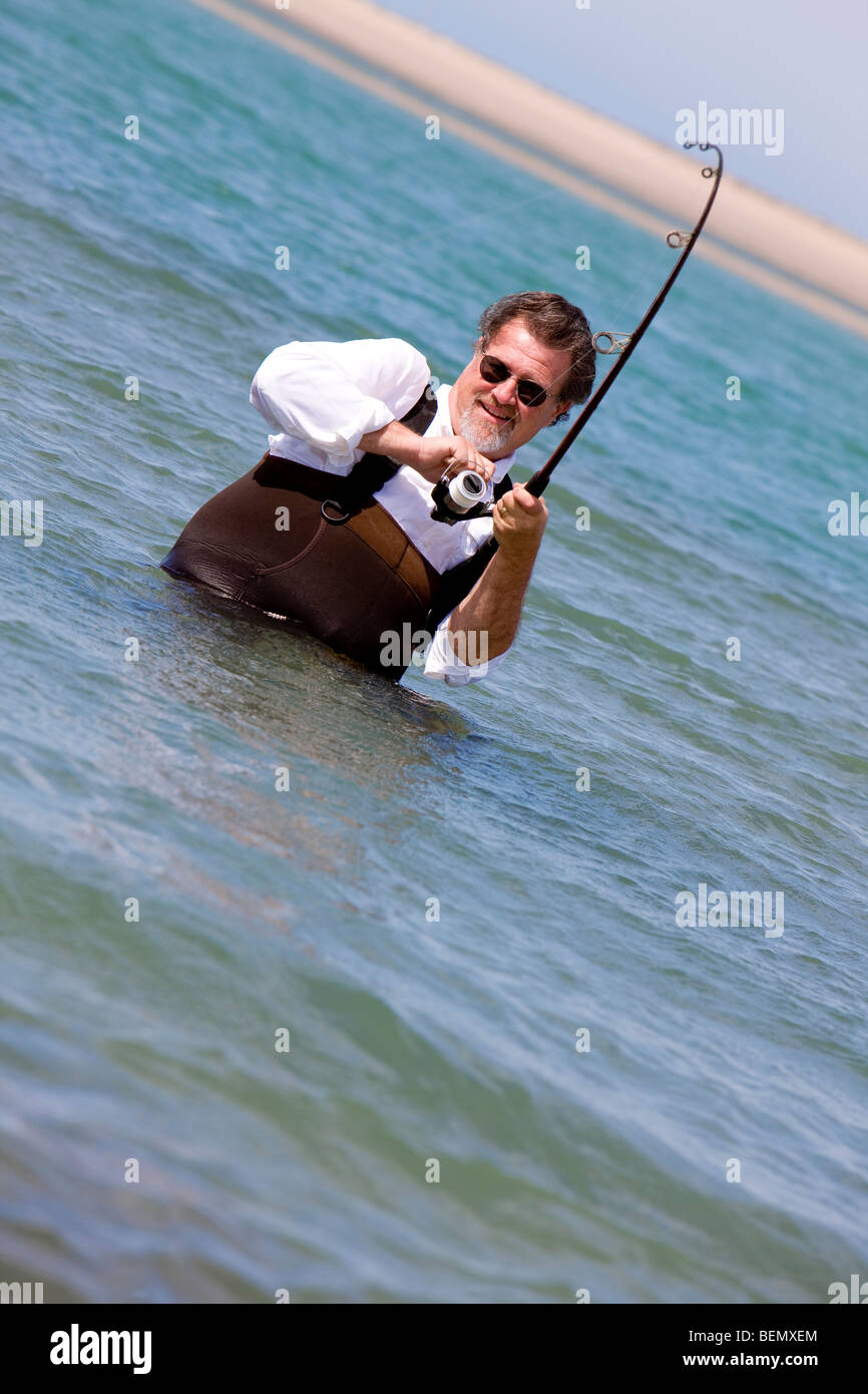 Fisherman reels in his catch. Stock Photo