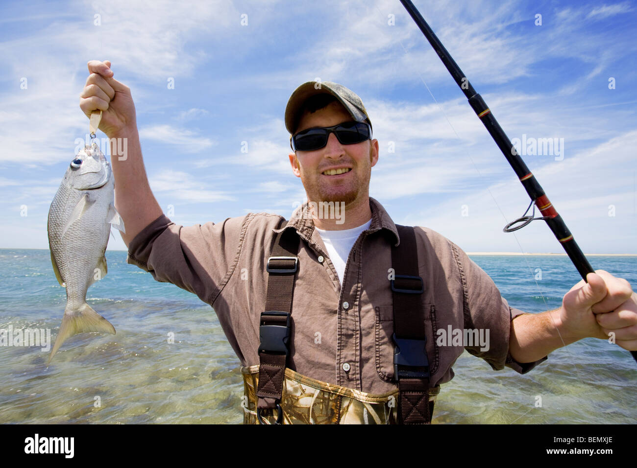 Happy fisherman shows off his catch. Stock Photo