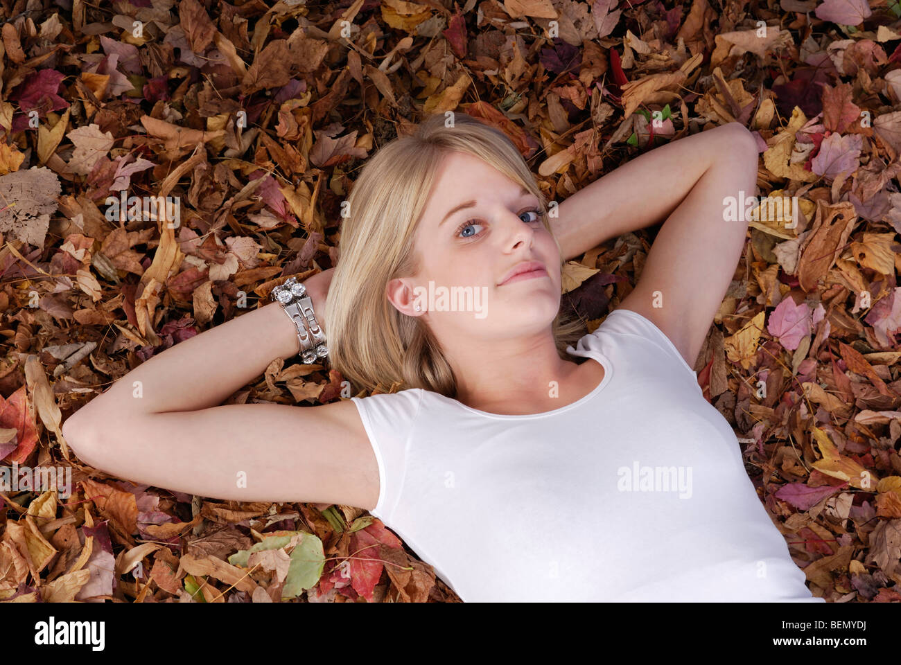 young girl lying on her back in autumn leaves Stock Photo - Alamy