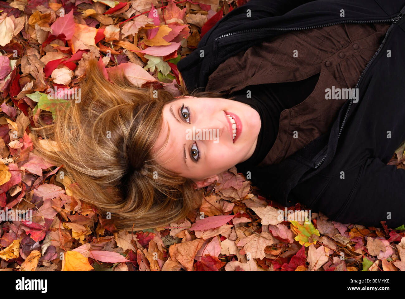 portrait of young woman lying in autumn leaves Stock Photo - Alamy