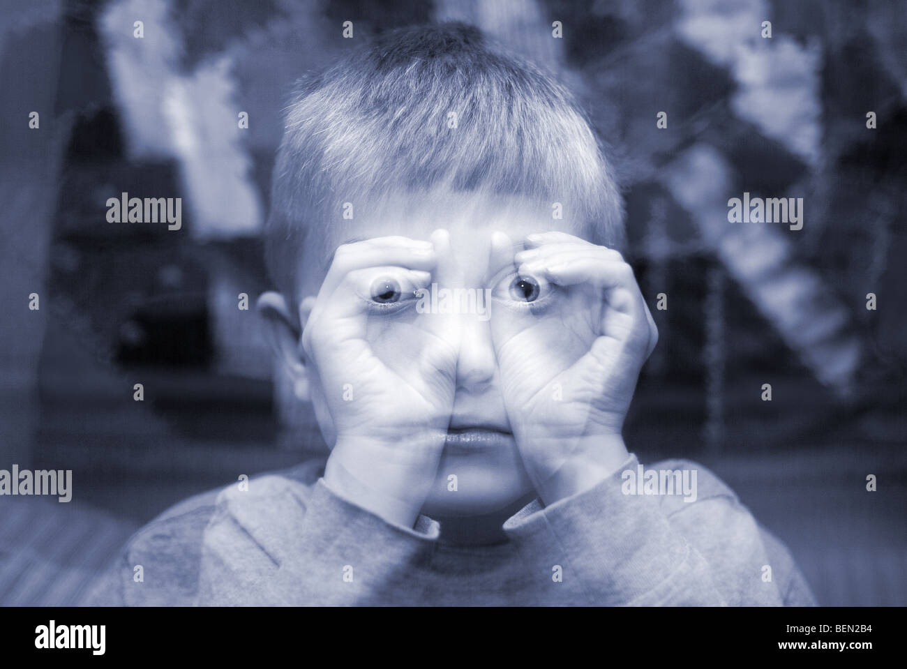 child making imaginary binoculars with hands in an ethereal double exposure Stock Photo