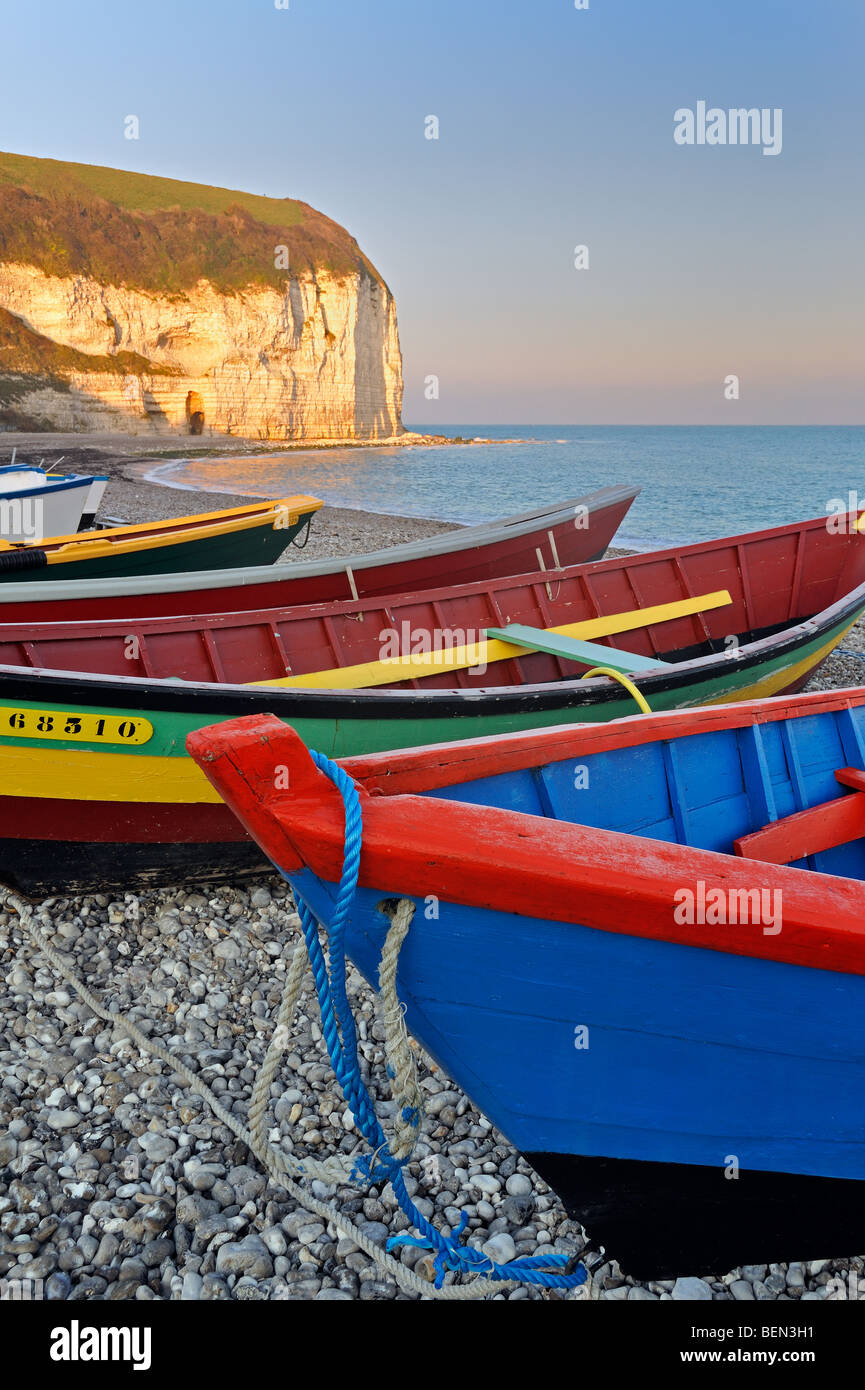 The Aval cliffs and colourful caïques, traditional wooden fishing boats on the beach at Yport, Normandy, Côte d'Albâtre, France Stock Photo