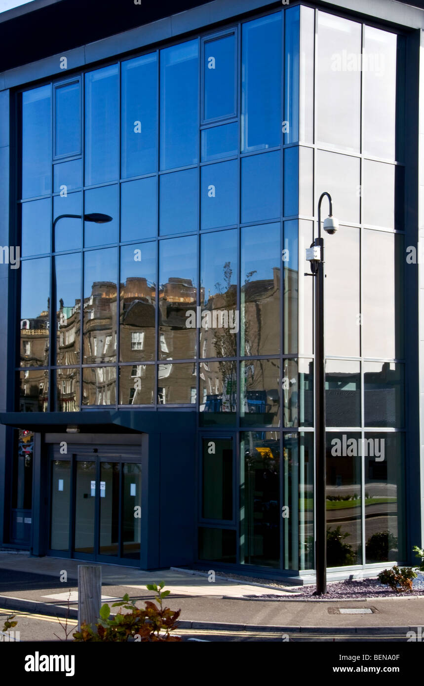 Mirrored images and reflections of tenement housing on modern office block windows in urban Dundee,UK Stock Photo