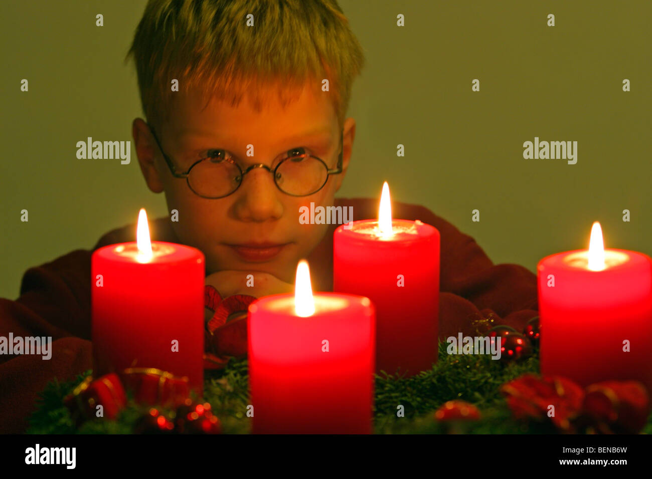 young boy looking joyfully at the burning candles on the Advent wreath
