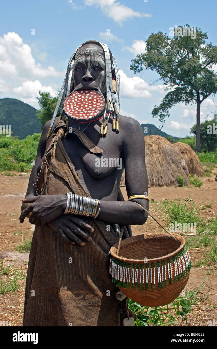 Close up of tribal Mursi woman with large clay plate in pierced lower ...