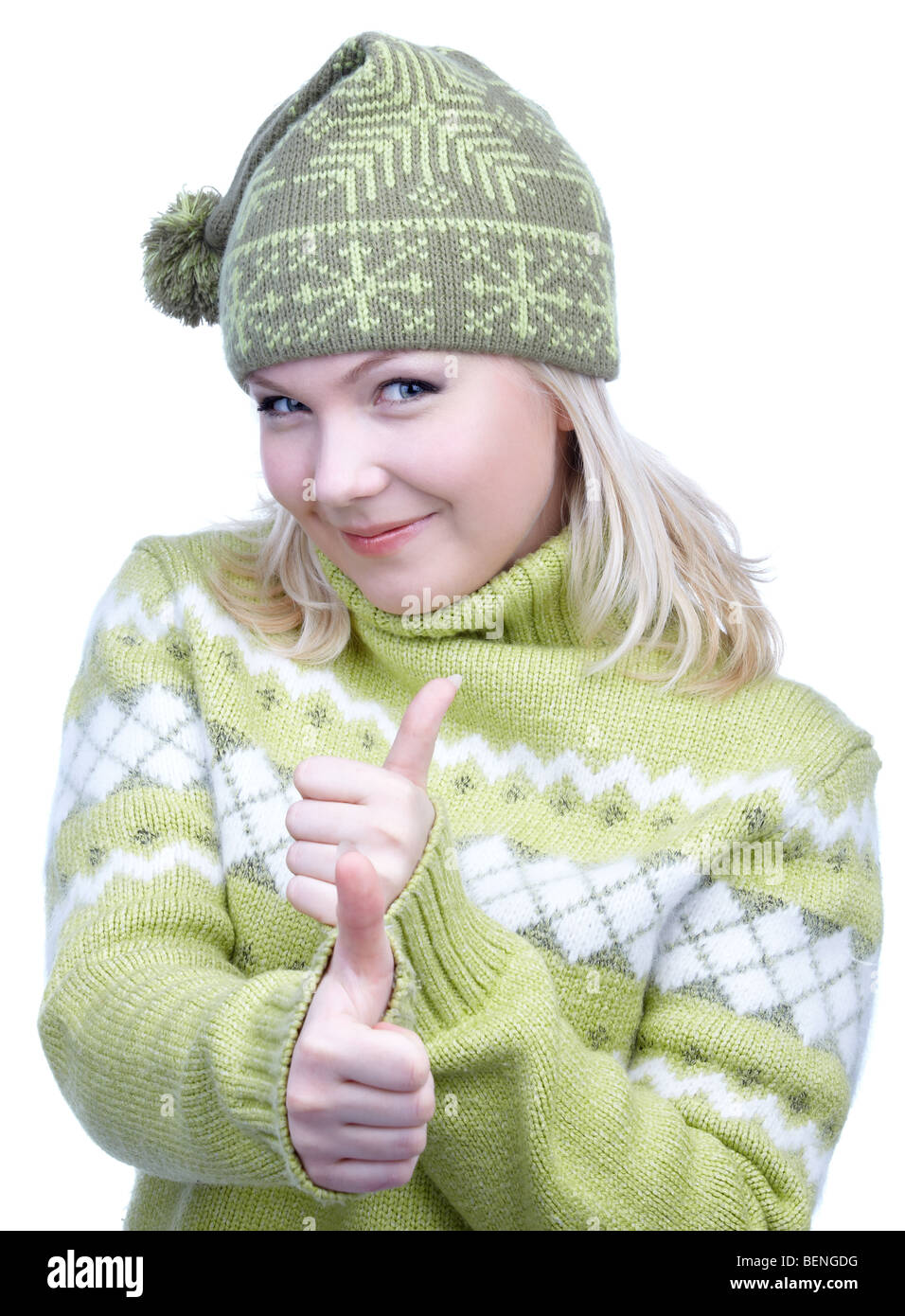 portrait of beautiful slavonic blonde girl in green sweater and winter cap with bob showing both thumbs up Stock Photo