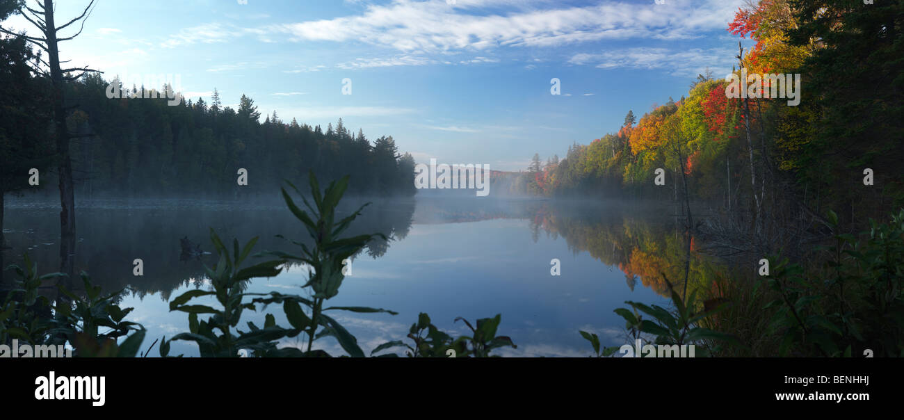 Mist over Smoke lake at dawn. Beautiful panoramic fall nature scenery. Algonquin Provincial Park, Ontario, Canada. Stock Photo