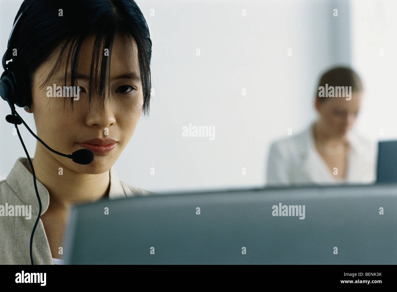 Young woman wearing headset and using computer Stock Photo