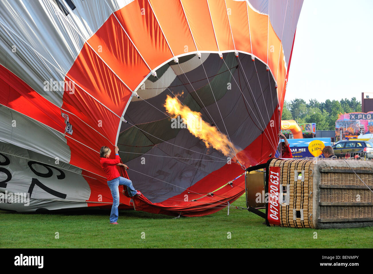 Balloonists / Aeronauts filling hot-air balloon with hot air from gas flame during ballooning meeting Stock Photo