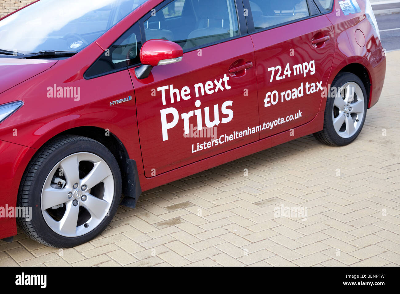 New Prius T3 hybrid red motor car with sign writing economu low fuel consumption Cheltenham UK Stock Photo