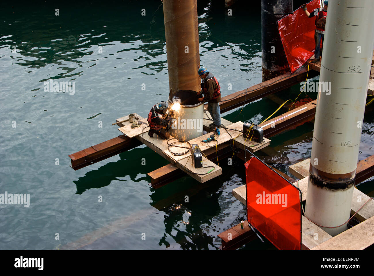 Spiral trails of sparks fly from electric arc welding rod as welders