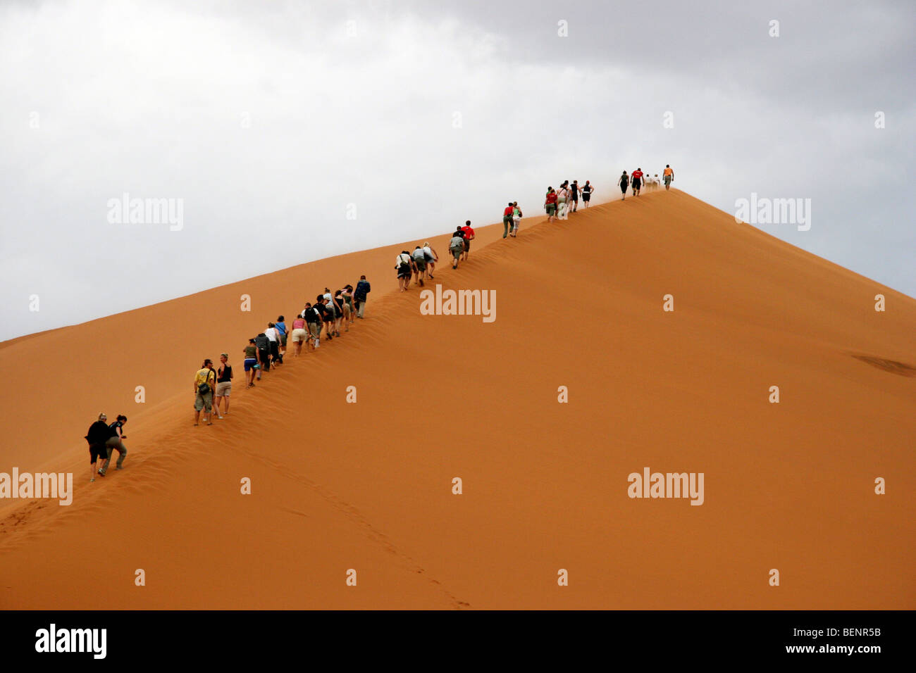 Tourists climbing red sand dune in Sossusvlei / Sossus Vlei in the ...