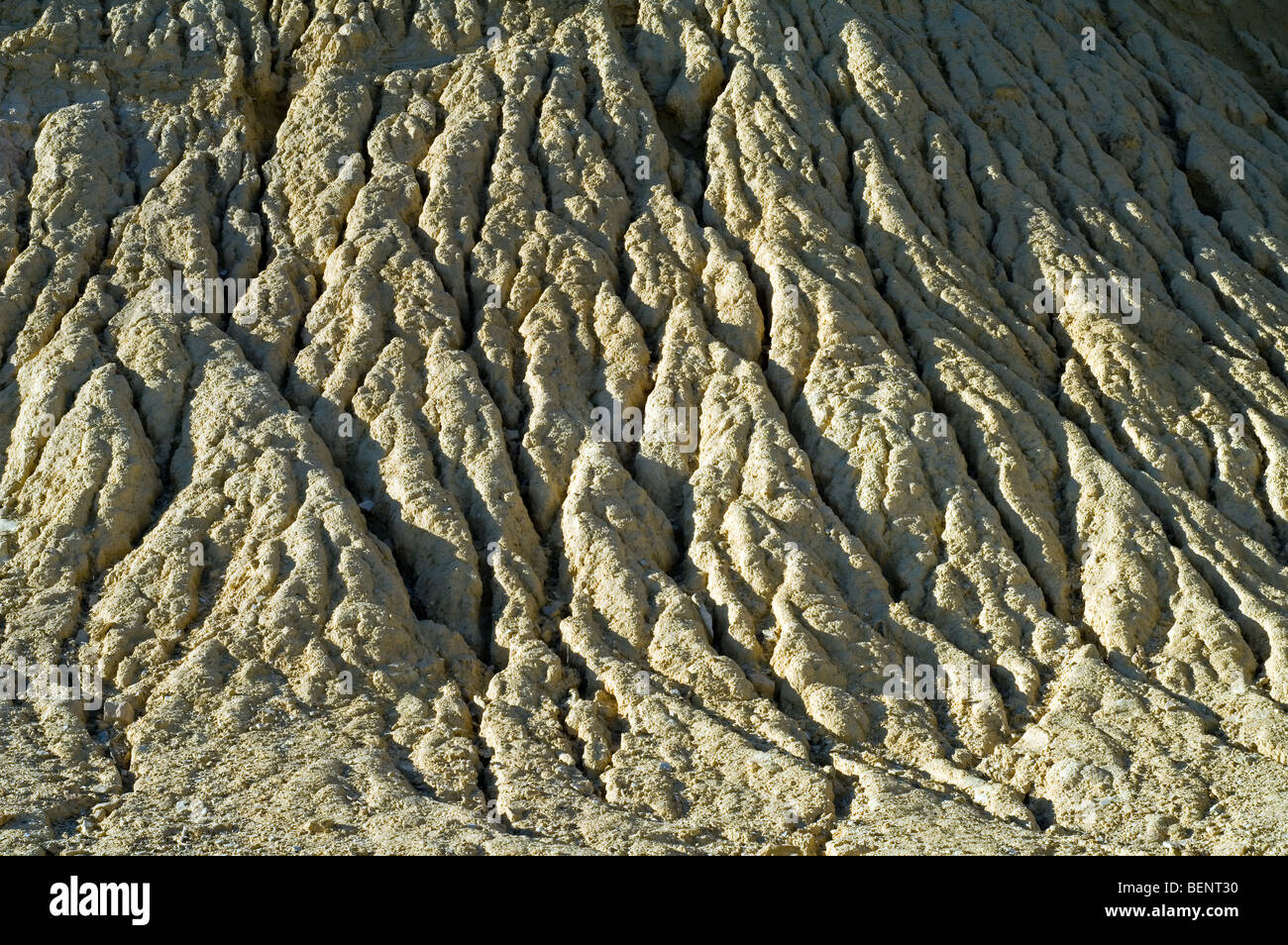 Gullies in soft rock of cliff caused by rain water erosion Stock Photo