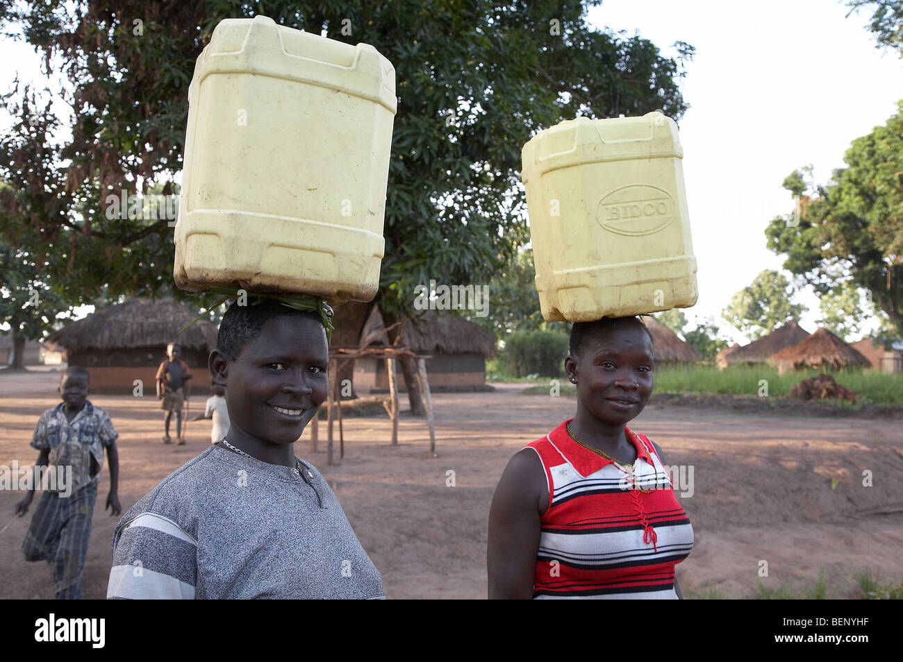SOUTH SUDAN Women carrying water from a hand pump well, early morning in Yei. PHOTO by SEAN SPRAGUE 2008 Stock Photo